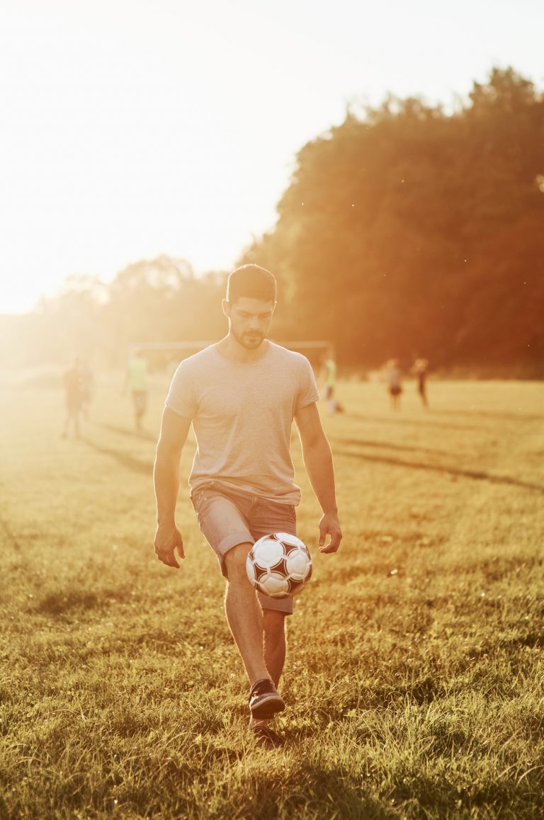 Man kick up the soccer ball. Training skills before he can show his own daughter how to do it